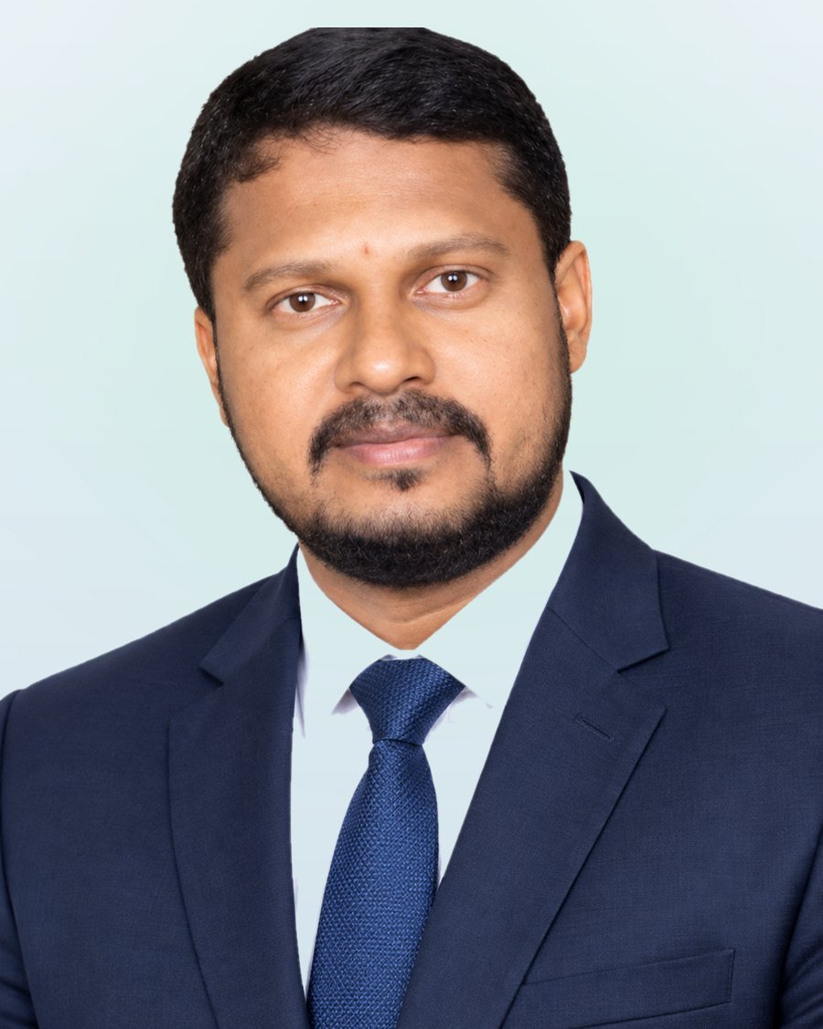 Portrait of the founder of Raksha Friend in a navy suit and blue tie